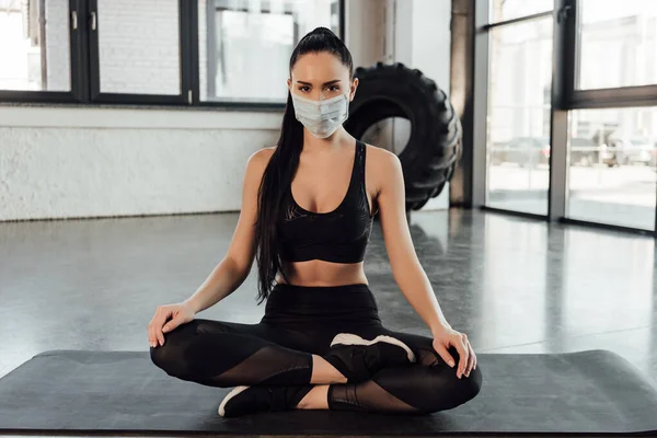 Brunette Sportswoman Medical Mask Sitting Crossed Legs Fitness Mat Looking — Stock Photo, Image