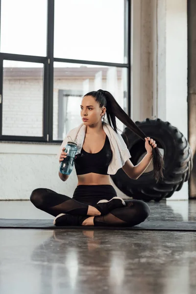 Sportswoman Crossed Legs Towel Touching Hair Holding Sports Bottle Fitness — Stock Photo, Image