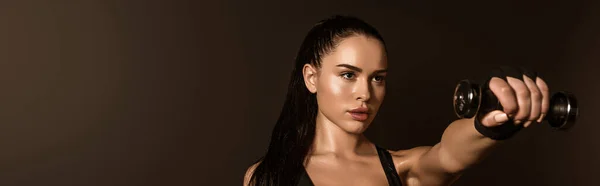 İnternet sitesi başlığı: Esmer sporcu kadın elinde dambıl, uzanmış elleri siyah üzerine izole edilmiş.