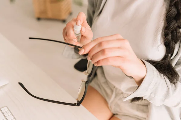 Обрезанный вид антисептика фрилансера на очки — стоковое фото