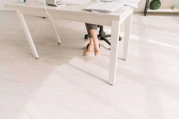 Обрезанный вид деловой женщины в туфлях на высоком каблуке, работающей дома — стоковое фото