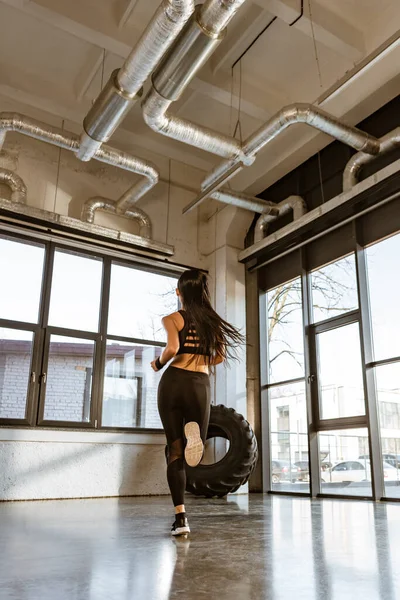 Back view of brunette sportswoman running on spot in gym — Stock Photo