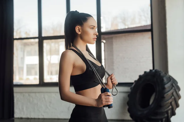 Beautiful sportswoman with skipping rope in sports center — Stock Photo