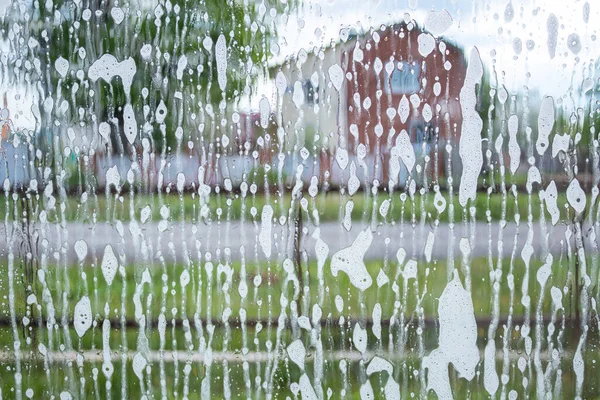 Une fenêtre savonneuse qui va être lavée. Fenêtre avec particules de mousse. Excellente texture — Photo