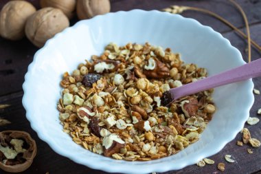 Sağlıklı bir yaşam tarzı. Tabakta sağlıklı ve besleyici müsli. Fındıklı müsli kahvaltısı için. Sağlıklı ve besleyici müsli. Tahta bir masanın üzerinde bir bardakta.