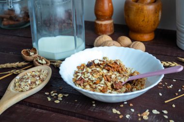 Sağlıklı bir yaşam tarzı. Tabakta sağlıklı ve besleyici müsli. Fındıklı müsli kahvaltısı için. Sağlıklı ve besleyici müsli. Tahta bir masanın üzerinde bir bardakta.