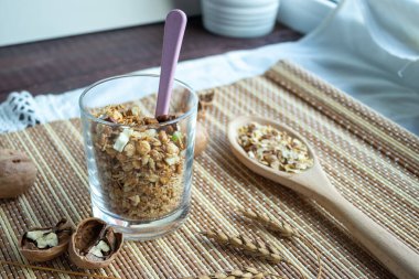 Sağlıklı bir yaşam tarzı. Bardakta sağlıklı ve besleyici müsli. Kahvaltı için, fındıklı doğal müsli. Müsli bir bardakta, tahta bir masada.