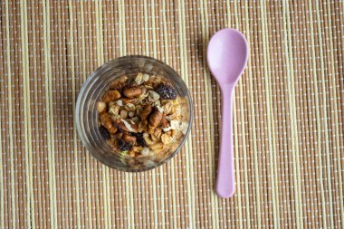 Sağlıklı bir yaşam tarzı. Bardakta sağlıklı ve besleyici müsli. Kahvaltı için, fındıklı doğal müsli. Müsli bir bardakta, tahta bir masada.