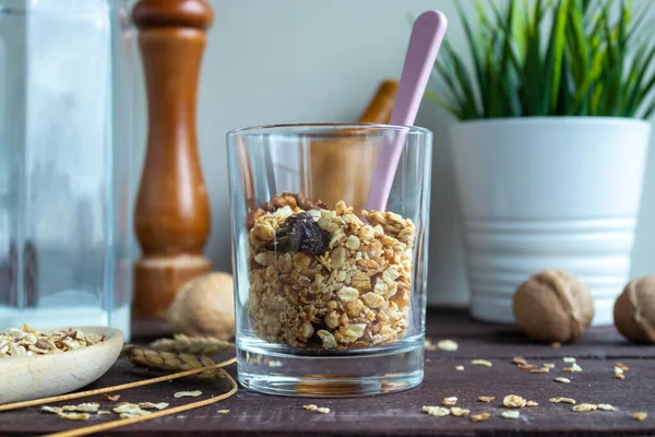 Muesli with nuts in a glass with a spoon. Healthy and healthy food on a wooden table — Stock Photo, Image
