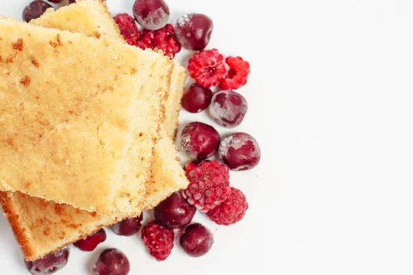 Beyaz arka planda yalıtılmış ahududu ve kirazlı Semolina keki