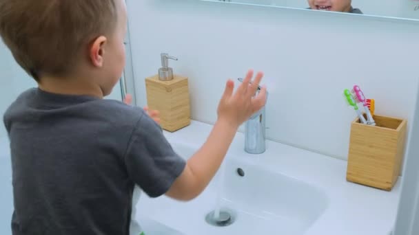 Las manos del niño encienden el agua en el lavabo, toman el jabón de la caja de jabón y se lavan las manos. Concepto de salud, limpieza y prevención de gérmenes y coronavirus en contacto con las manos — Vídeos de Stock