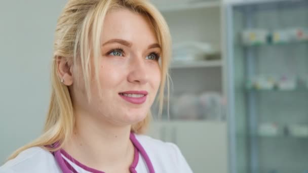 Ung kaukasisk kvinnlig professionell läkare läkare bär vit medicinsk rock stetoskop titta genom fönstret, tänka, drömma och planera framtida karriär — Stockvideo