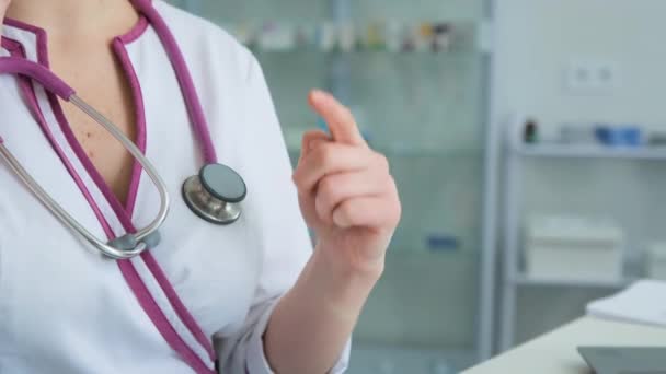 Пристегнуться к врачу Госпиталь женщина врач жесты рукой и считает пальцами в клинике в белом халате сидя — стоковое видео
