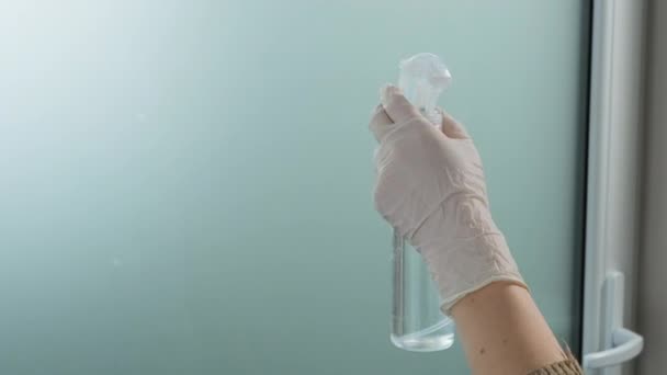 Main dans les gants blancs fenêtre de nettoyage avec chiffon jaune et spray nettoyant à la maison — Video