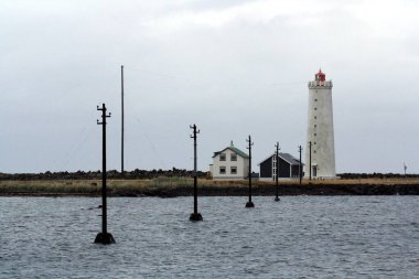 Grtta Adası Deniz Feneri. Düşük gelgitte ulaşılabilen bir adada deniz feneri, kuzey ışıklarını görmek için çok popüler. Atlantik Okyanusu kıyısı. Kuzey Atlantik kıyıları Reykjavik, İzlanda.
