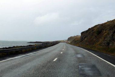 Reykjavik 'in kuzeyindeki çevre yolunda. İzlanda 'nın batı kıyısında bulutlu bir yaz günü.