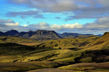 İzlanda 'nın güneyinde kayalardan, dağlardan, vadilerden ve yeşil otlardan oluşan güzel vahşi ve volkanik bir manzara..