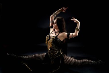 İp içinde bir kabile dansçısı... Çok seksi bir kadın, bir sürü aksesuarı olan bir güzellik. İpte oturan bir kabile dansçısı..