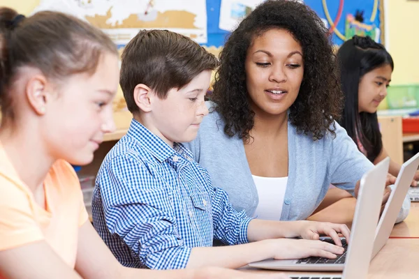 Profesor ayudando a los alumnos de primaria masculina en la clase de informática — Foto de Stock