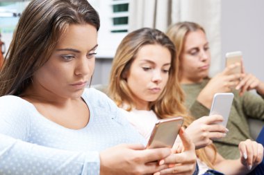 Genç kız evde cep telefonunu kullanarak grubu