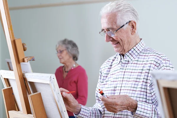 Пожилые люди, посещающие уроки живописи вместе — стоковое фото