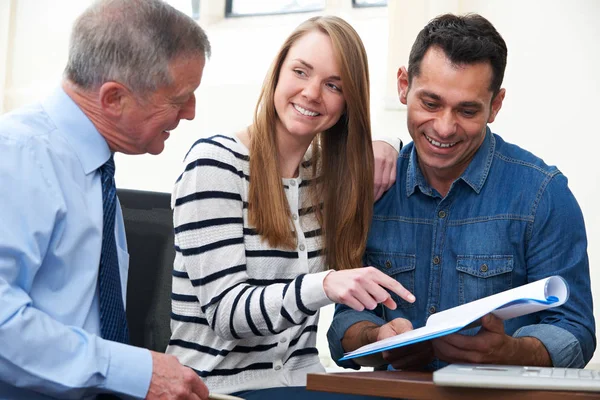 Couple With Financial Advisor Studying Document In Office — Stock Photo, Image