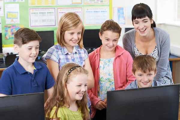 Basisschool leerlingen met leraar In de Computer klasse — Stockfoto