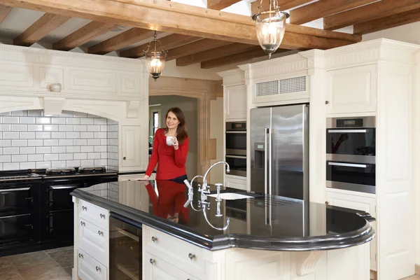 Mature Woman Standing In New Luxury Fitted Kitchen — Stock Photo, Image