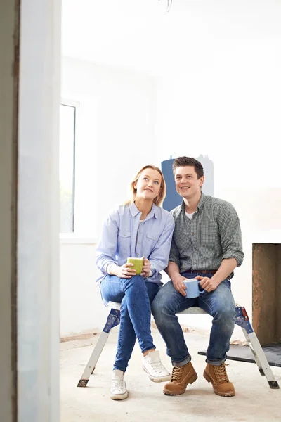 Ehepaar sitzt in saniertem Anwesen — Stockfoto