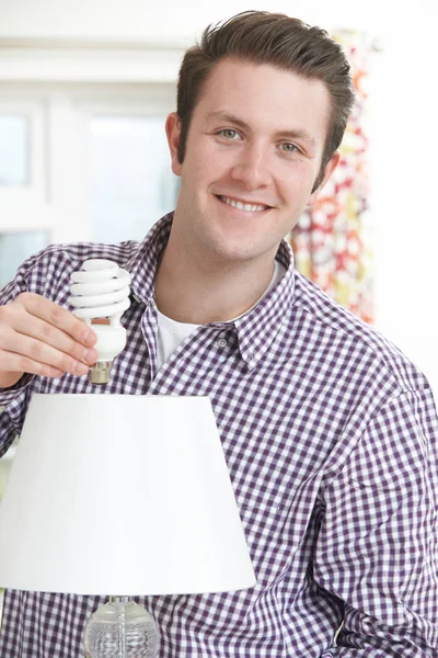 Man Putting Low Energy Lightbulb Into Lamp At Home — Stock Photo, Image