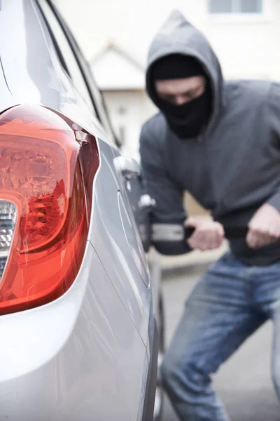 Maskierter bricht mit Brechstange in Auto ein — Stockfoto