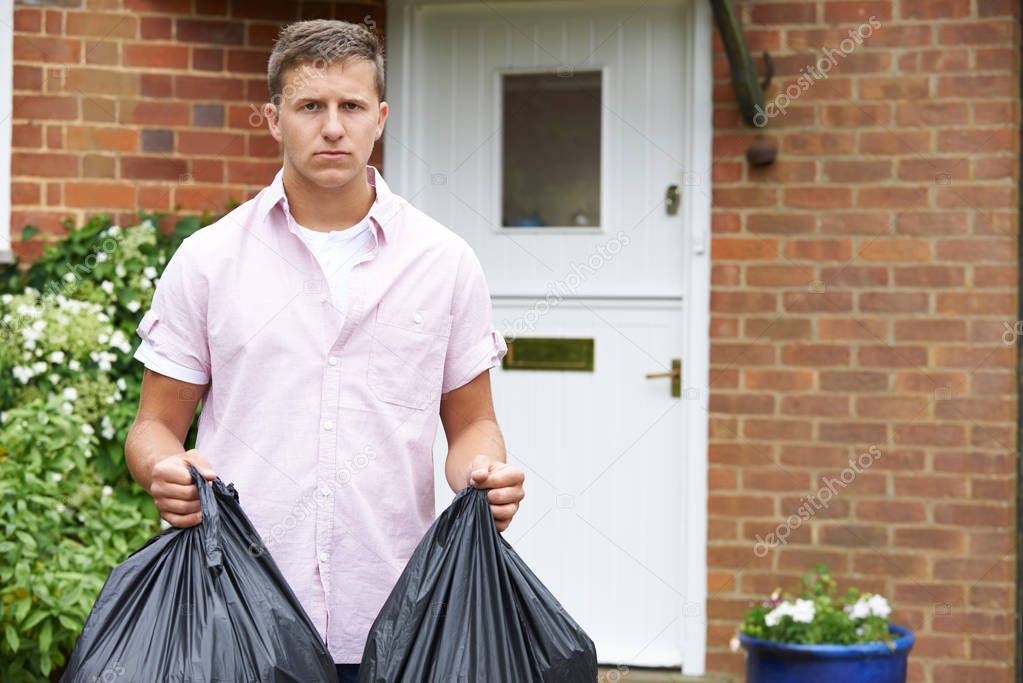 Portrait Of Man Taking Out Garbage In Bags