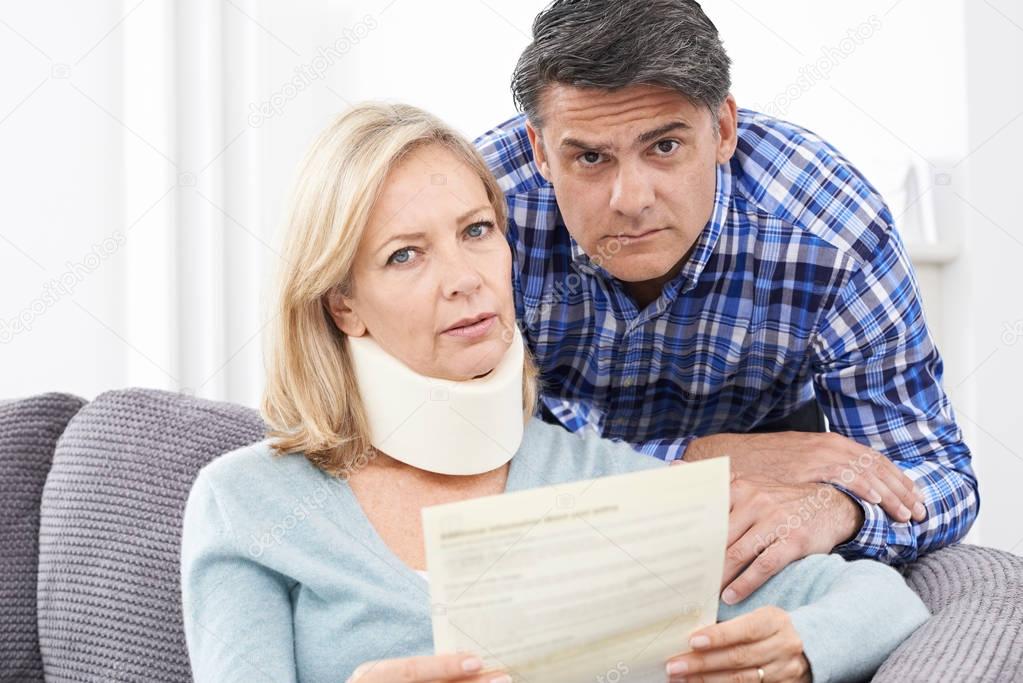 Couple Reading Letter About Woman's Injury