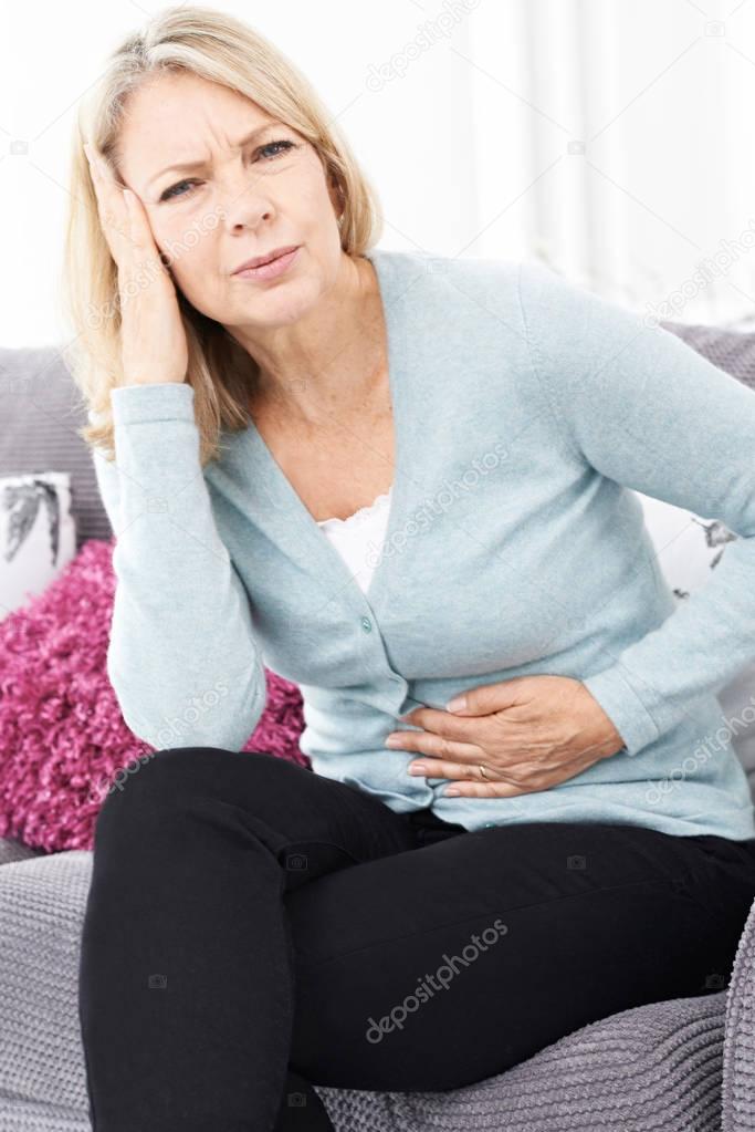 Mature Woman Suffering From Stomach Pain And Headache 