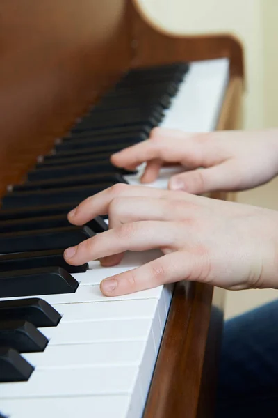 Fechar as mãos da criança tocando piano — Fotografia de Stock