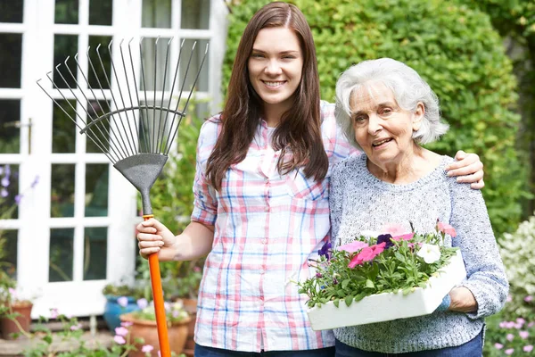 Teenage Granddaughter Helping Grandmother In Garden — Stock Photo, Image