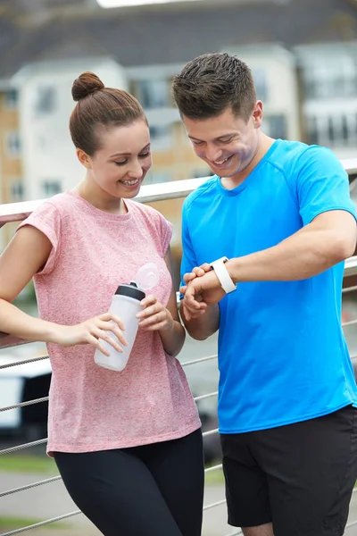 Couple Looking At Activity Tracker Whilst Exercising In City — Stock Photo, Image
