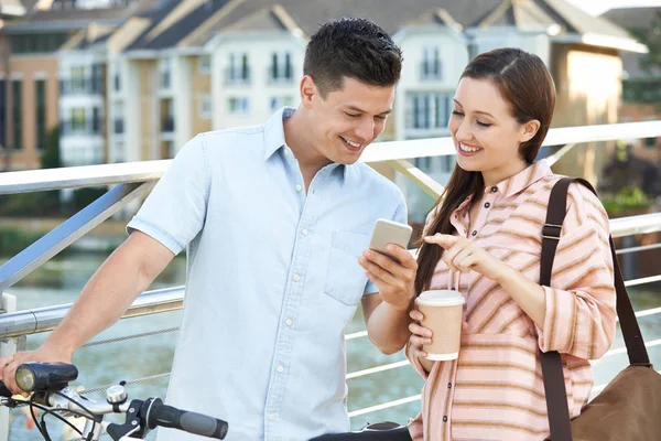 Young Couple Looking At Phone On Way To Work In Urban Setting — Stock Photo, Image