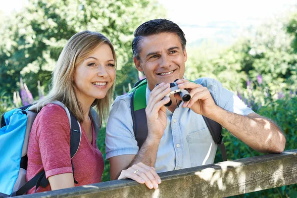 Mature Couple Hiking In Countryside Looking Through Binoculars — Stock Photo, Image