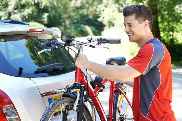 Cycliste masculin prenant le vélo de montagne du support sur la voiture — Photo