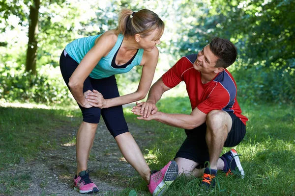 Mature Woman Exercising With Personal Trainer In Park — Stock Photo, Image