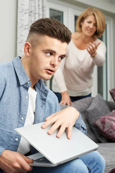 Adolescente niño ocultando el uso de Internet de la madre — Foto de Stock