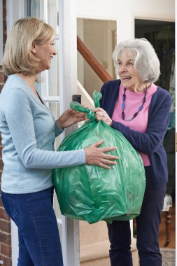 Woman Taking Out Trash For Elderly Neighbour clipart