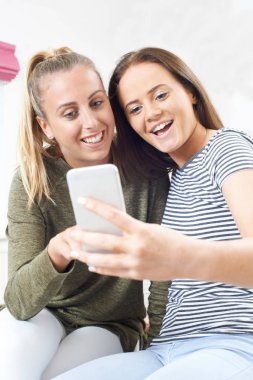Genç kızlar cep telefonuna kısa mesaj okuma