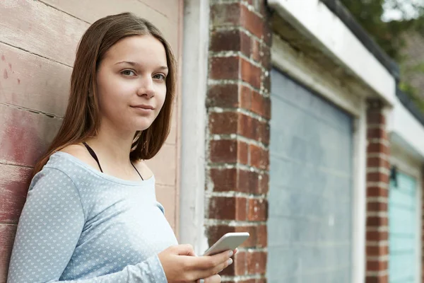 Menina adolescente mensagens de texto no telefone móvel em configuração urbana — Fotografia de Stock