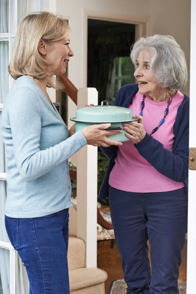 Frau bringt Essen für ältere Nachbarin — Stockfoto