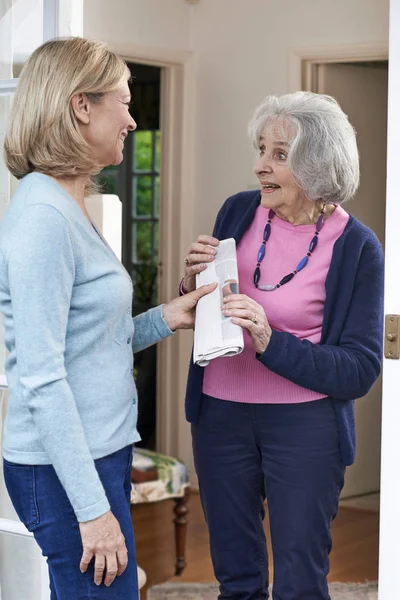 Mulher entregando jornal ao vizinho idoso — Fotografia de Stock