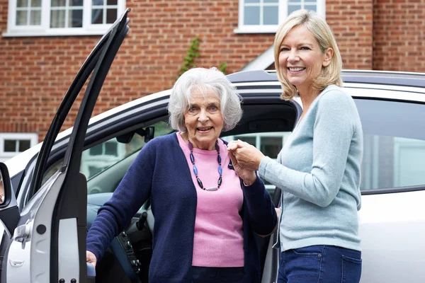 Vrouwelijke buurman geven Senior vrouw A Lift In auto — Stockfoto
