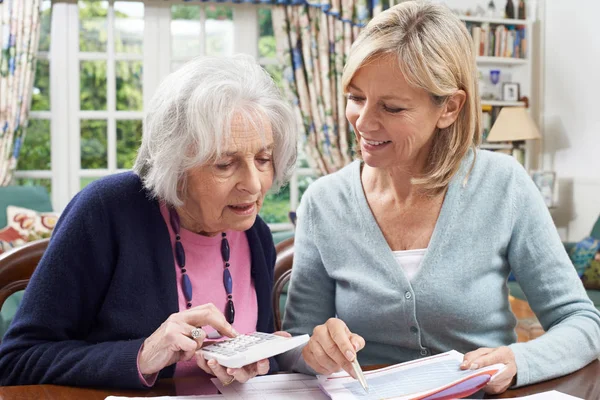 Mujer vecina ayudando a una mujer mayor con finanzas domésticas —  Fotos de Stock