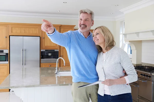 Couple mature regardant autour de la cuisine de la maison à vendre — Photo